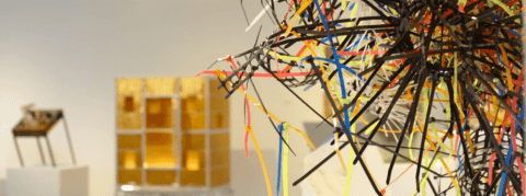 Close up of multi colored zip ties connected into various webs in a gallery.