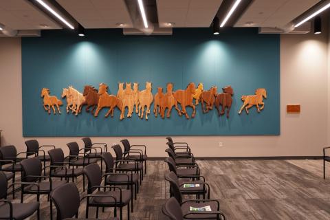 Wooden mural of horses on a wall