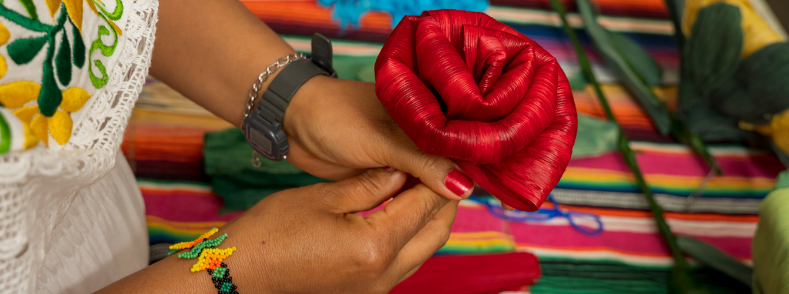 Two hands holding a folded fabric that resembles a flower.