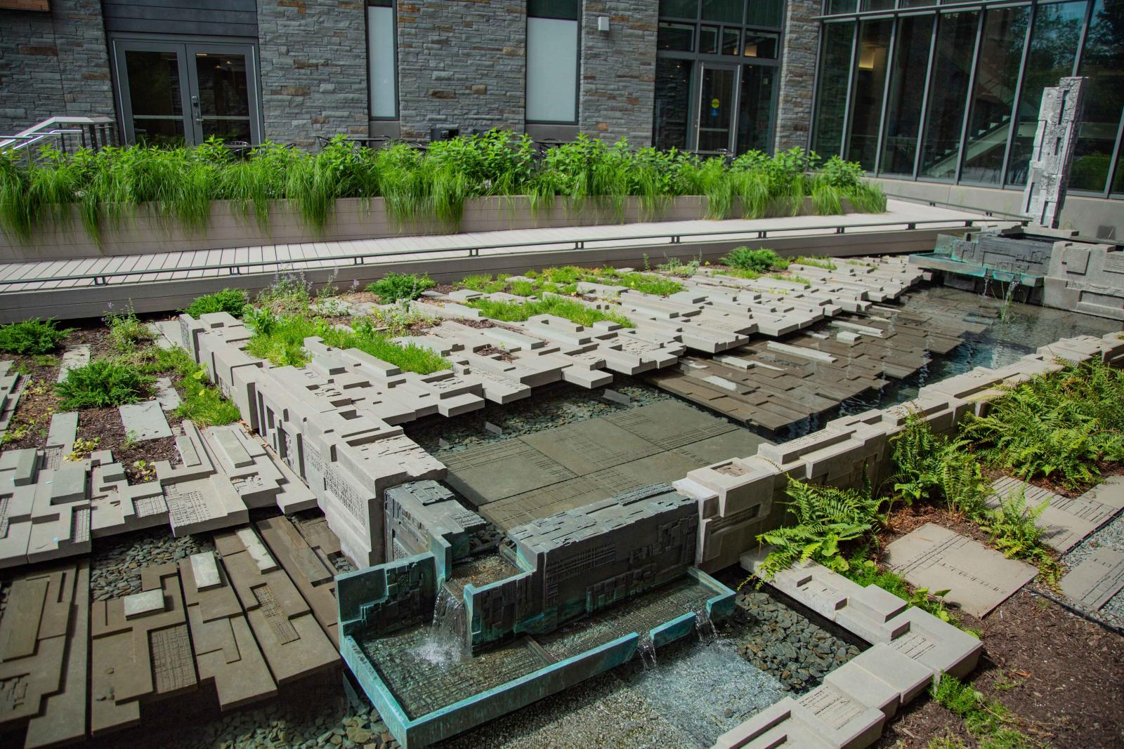 Public art sculpture of wood and greenery in water