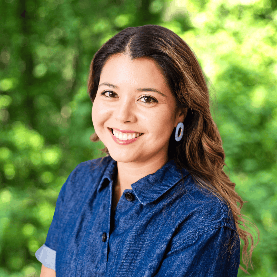 Headshot of Cathy Teixeira. Woman with long hair smiling at camera wearing a denim blouse.