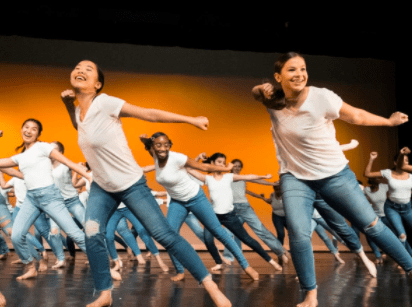 Synchronized dancers on stage in jeans