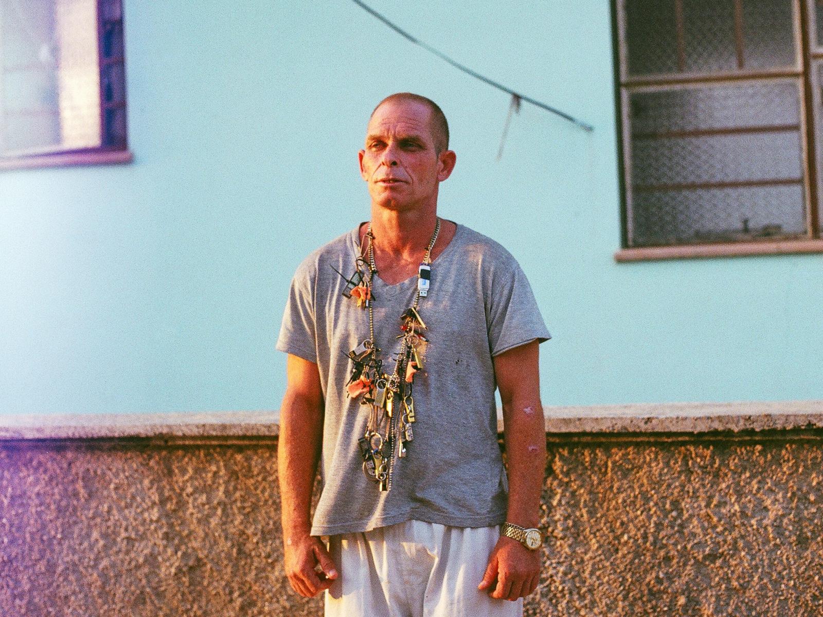 Film still from the production of Armageddon 2. Michel, a local Judo instructor, wearing a prop necklace custom made for the film using found materials and locally sourced e-waste. The USB necklace holds illegally torrented movies, television, and images.