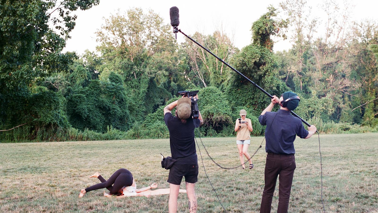 Film still from the production of “My Expanded View,” showing a distracted film crew and a yoga instructor stuck in a pose. This film was written during a period where I was working as a camera operator on reality TV shows. I found that when working on those sets I was way more interested in the dynamics going on behind the camera than by what was being filmed. I wanted to create a film that showed the collapse of the film set structure and blurred the line between who is filming and who is being filmed.