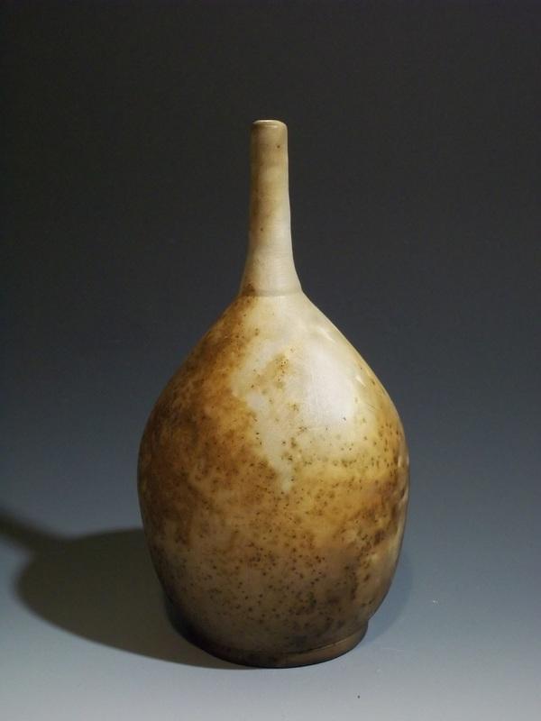 A hand-thrown porcelain bottle then pit-fired with the introduction of gunpowder, these bottle is one of a series of wares that marries beautiful forms and violent firing processes.  