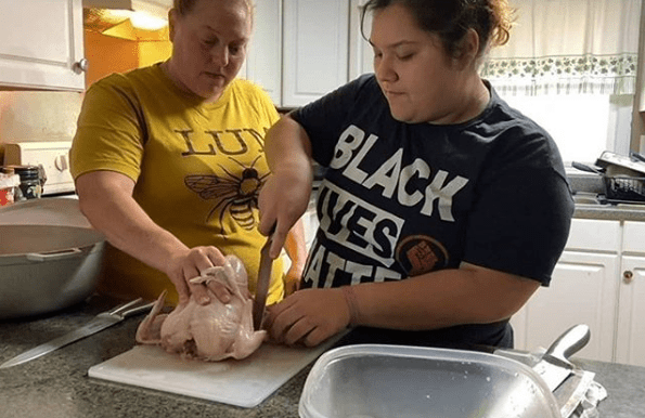 Two women cooking a chicken